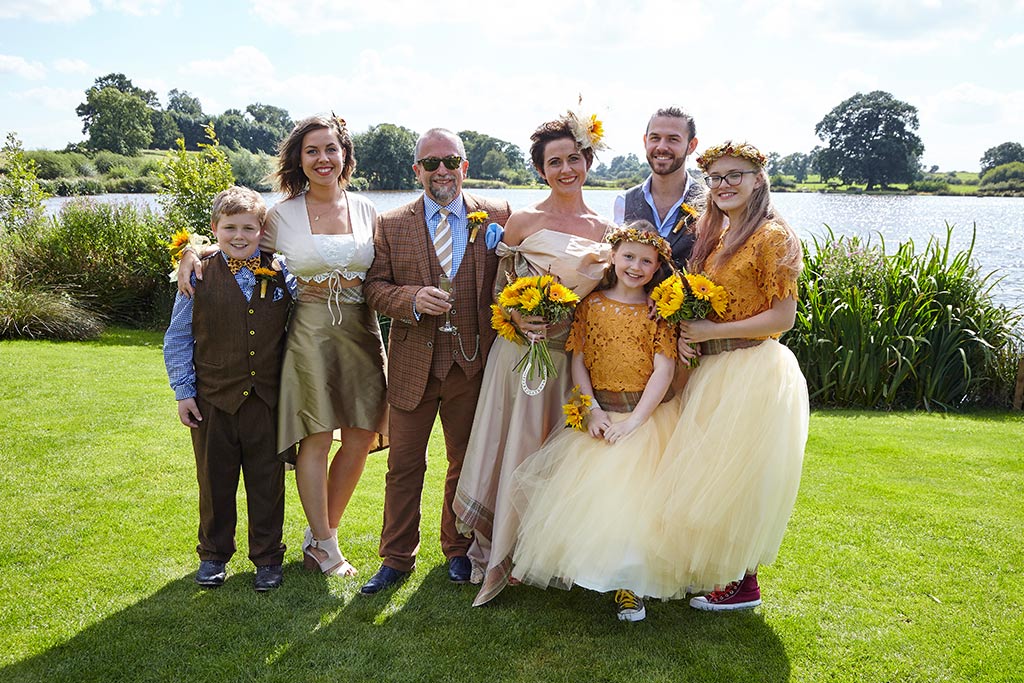 Wedding party on lawn in front of the lake