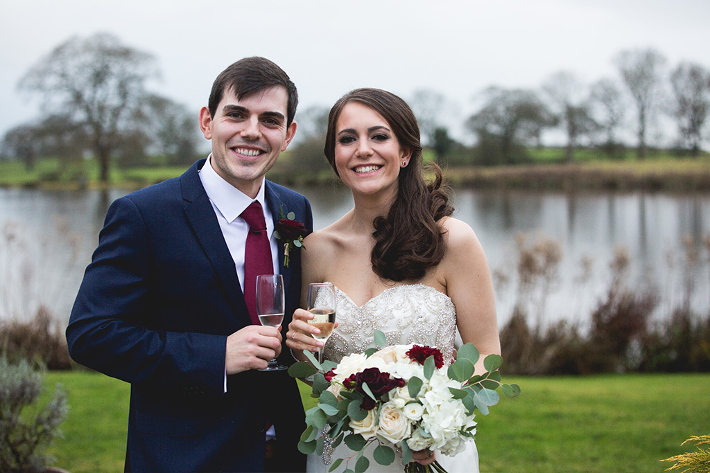 Bride and groom stood infront of the lake at sandhole oak barn