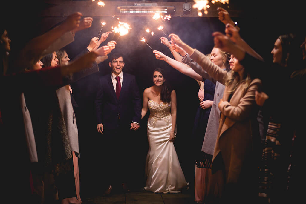 Sparklers held above bride and groom in wedding celebrations