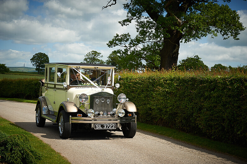 A vintage cream Rolls Royce arriving at Sandhole Oak Barn