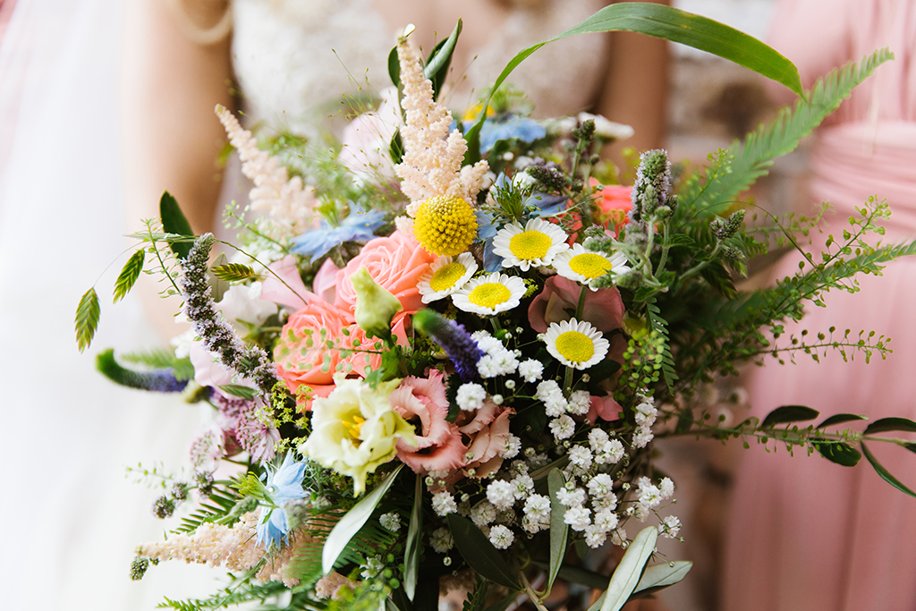 The bride’s bouquet was a stunning mix of colourful summer flowers and lush foliage at this summer wedding at Sandhole Oak Barn
