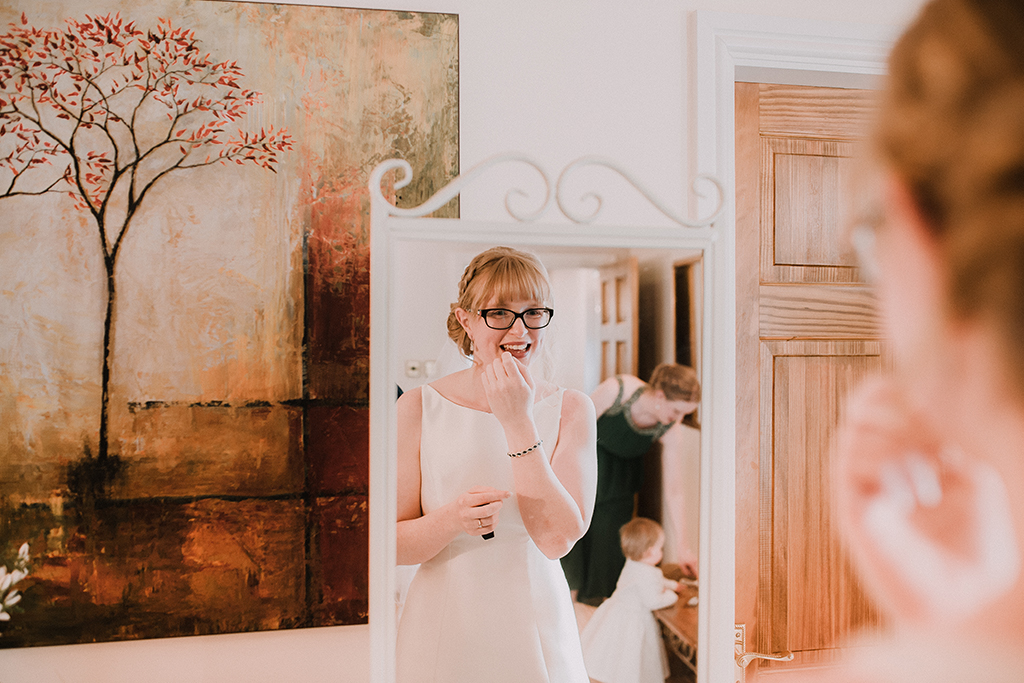 The bride makes the final touches to her look as she gets ready for her wedding ceremony at Sandhole Oak Barn