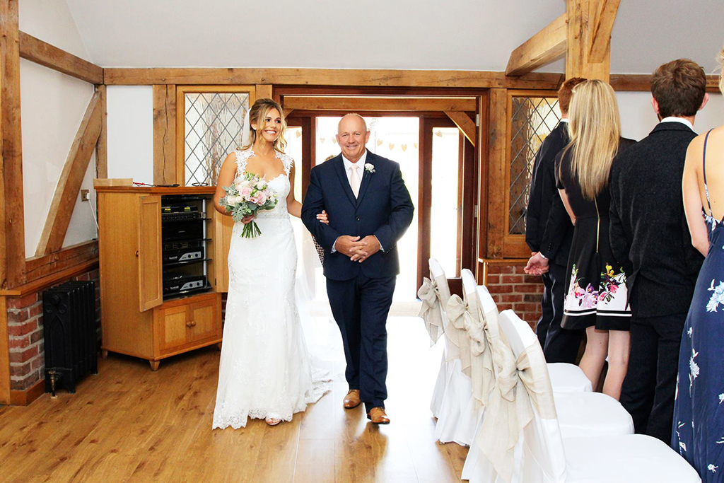 The bride and father of the bride walk down the wedding aisle