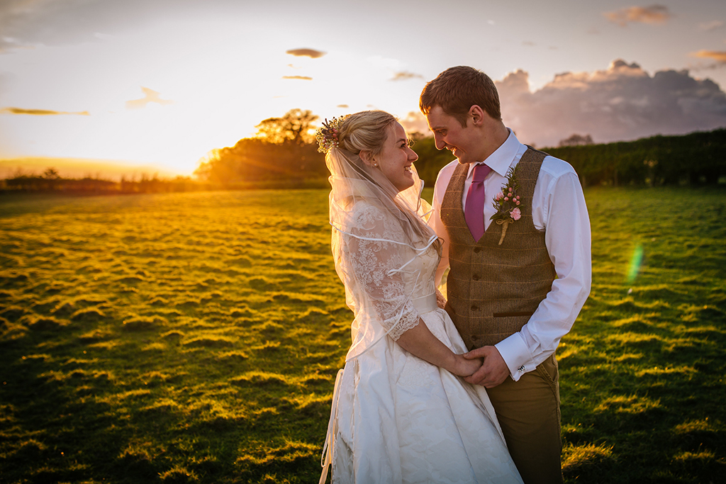 The happy couple have their photo taken in the stunning sunset at this rural wedding venue in Cheshire