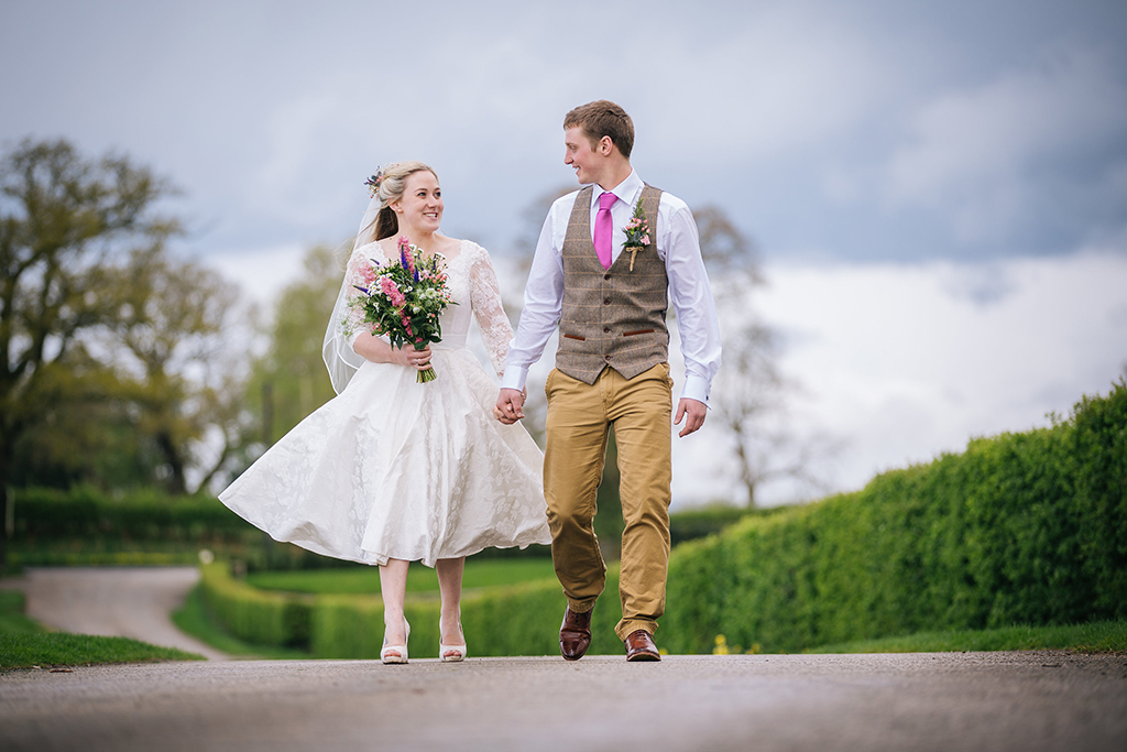 The happy newly weds take a stroll down the drive at Sandhole Oak Barn at their rustic barn wedding