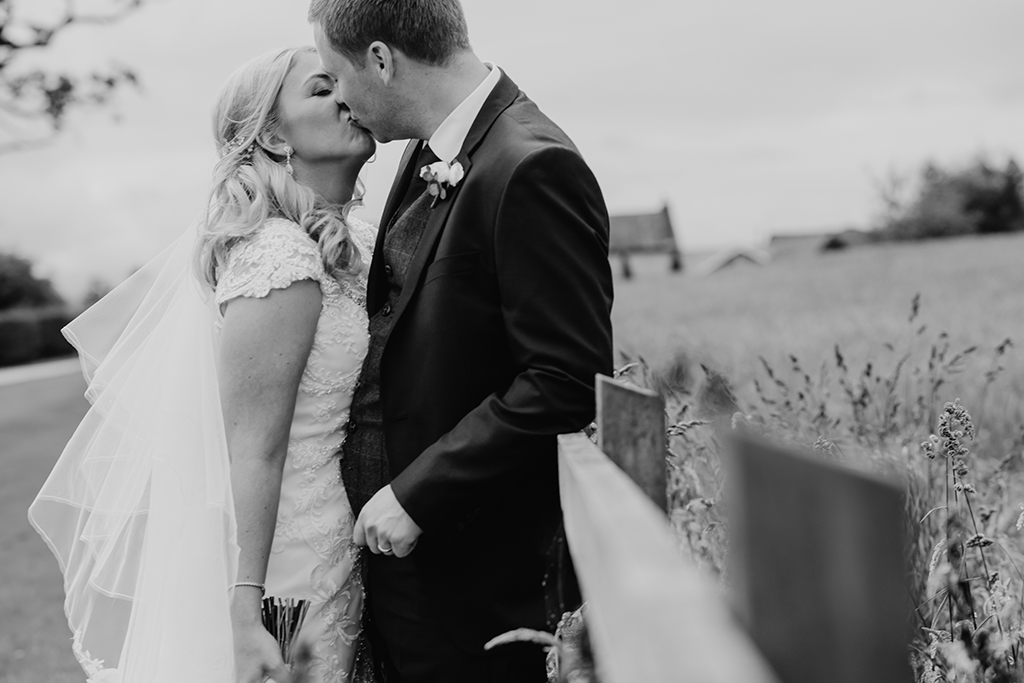 The happy couple steal a moment away from guests and share a kiss