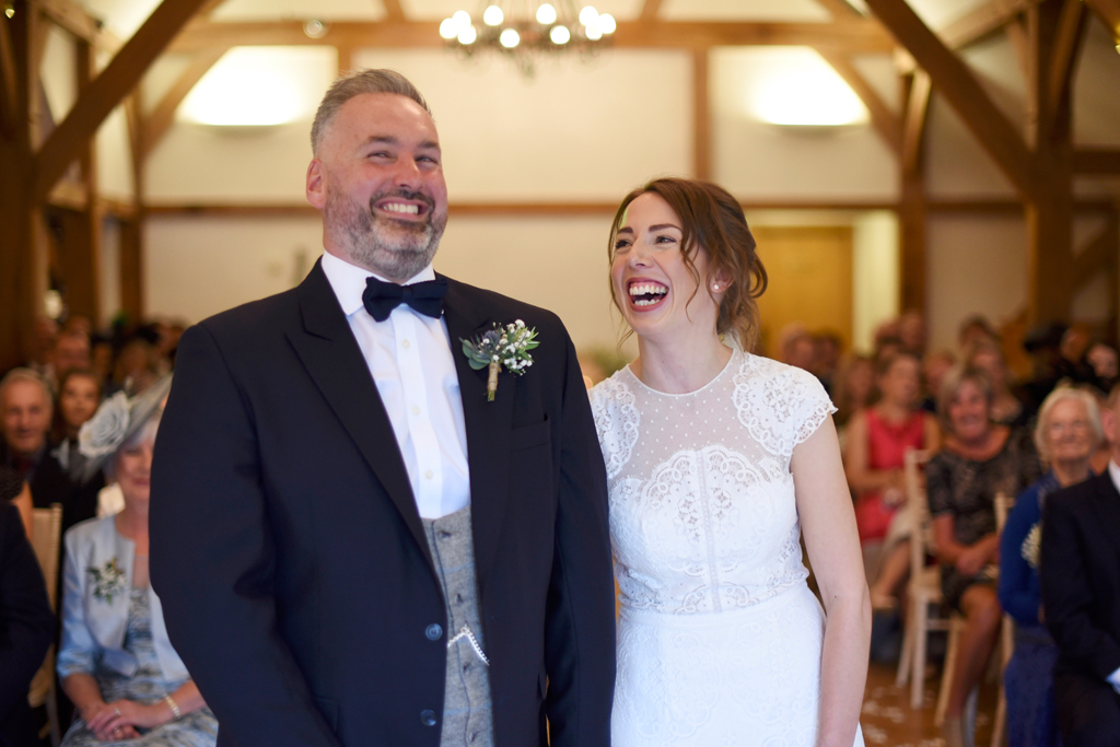 The happy newlyweds have a giggle at their wedding ceremony at Sandhole Oak Barn
