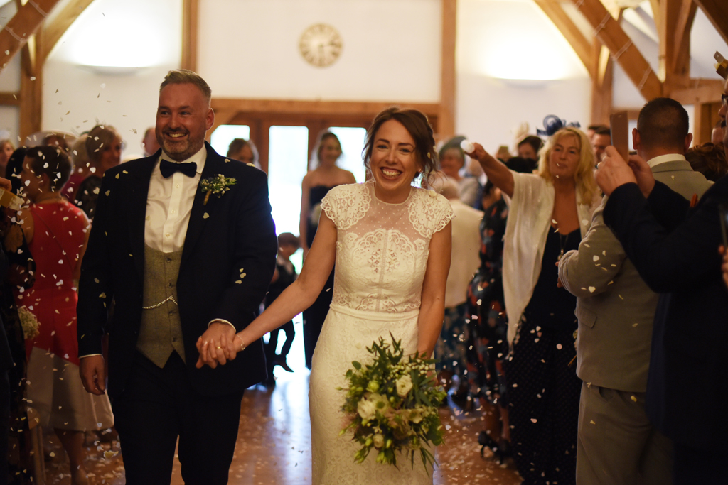 The happy newlyweds have confetti thrown over them