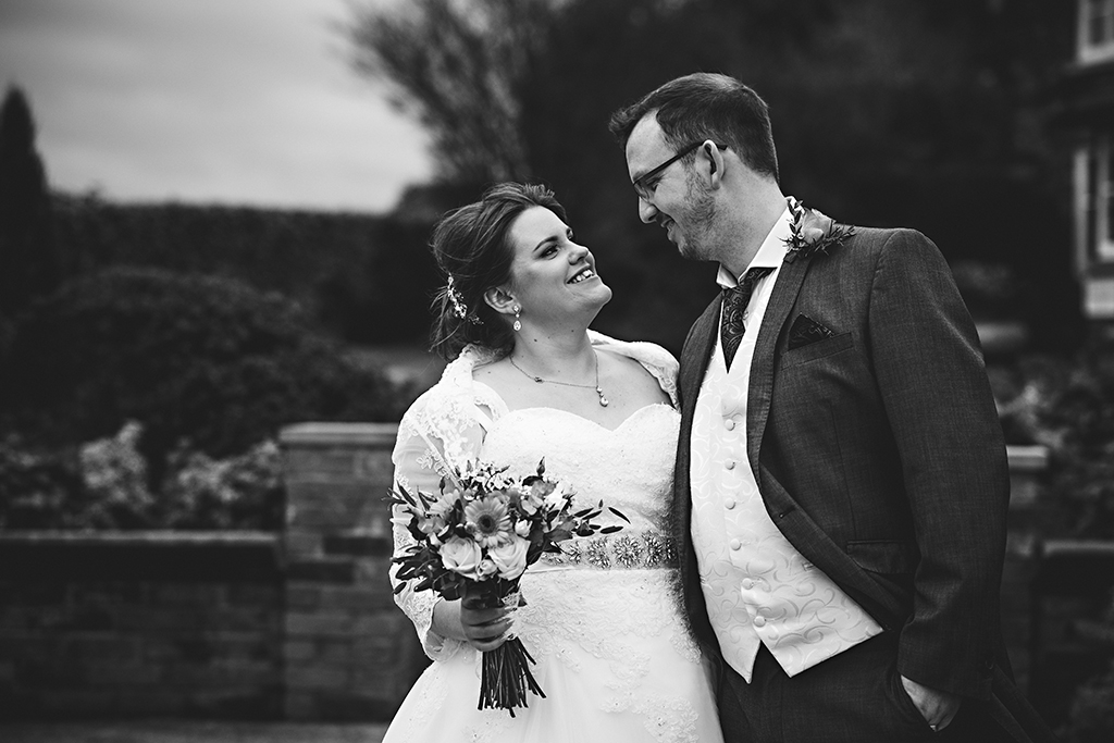 the happy couple take a moment to pose for a photo at Samdhole Oak Barn in Cheshire