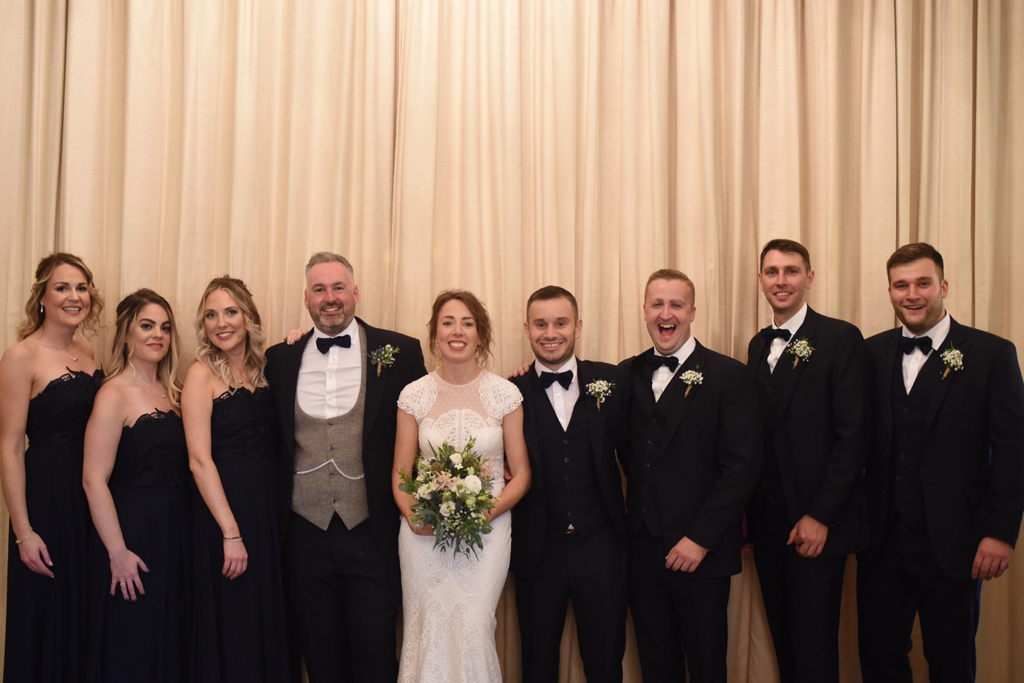 The happy newlyweds pose for a wedding photo with the wedding party at Sandhole Oak Barn