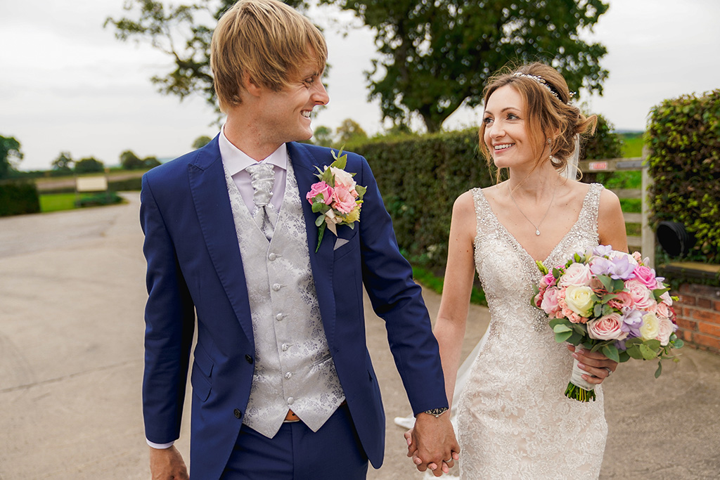 The happy newlyweds pose for a photo outside at Sandhole Oak Barn Cheshire