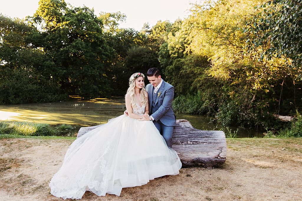 The happy newlyweds pose for a photo in the sunshine at this rural barn wedding in Cheshire
