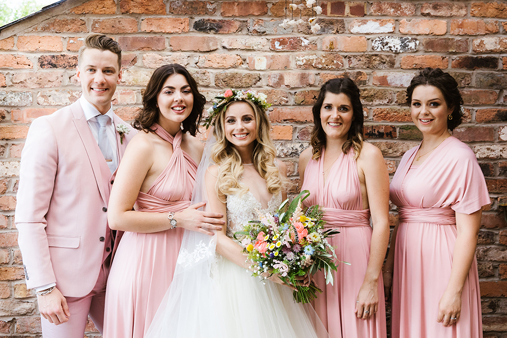 The bridesmaids wore pastel pink dresses and the bridesman a pastel pink three piece wedding suit at this barn wedding in Cheshire