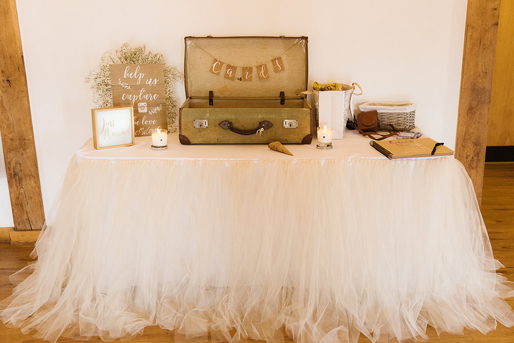The bride chose a pretty white tulle skirt to decorate the card and message table at her wedding at Sandhole Oak Barn
