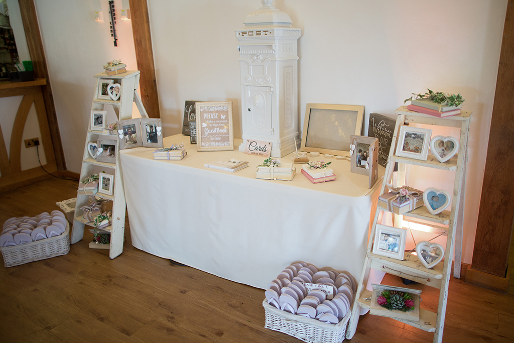 The card table at this spring wedding was decorated with lots of soft white wedding decorations at Sandhole Oak Barn in Cheshire