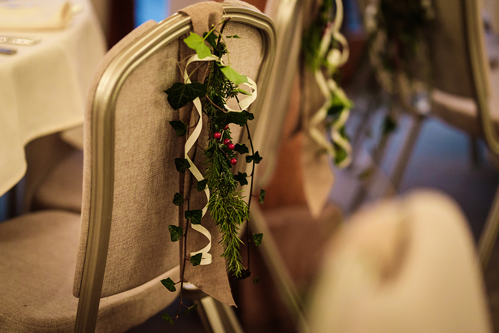 Decorate chairs with arrangements of festive ivy and red berries for that wonderfully wintery feel at your winter wedding at Sandhole Oak Barn