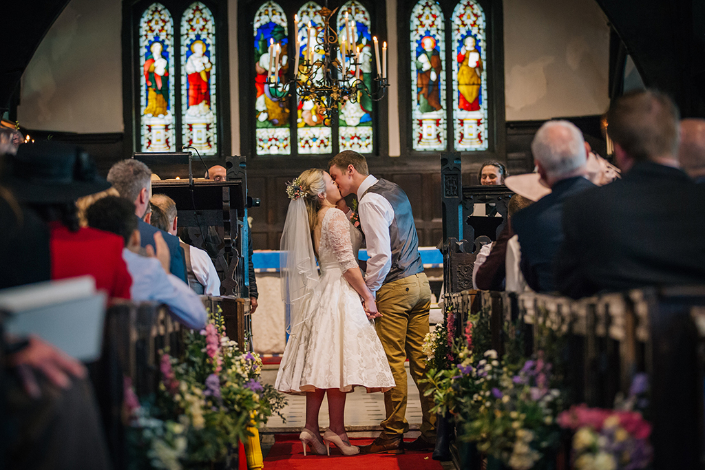 The bride and groom share their first kiss as husband and wife at their church wedding in Cheshire