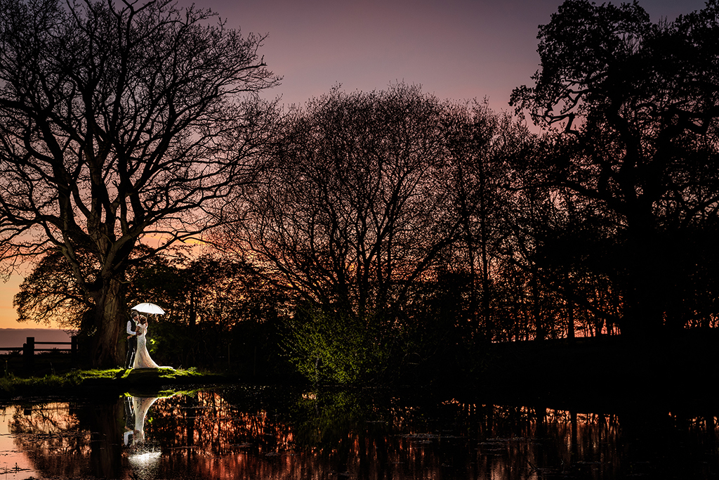 The sun setting over the lake creates the perfect backdrop for those dramatic wedding shots at this rural barn venue in Cheshire