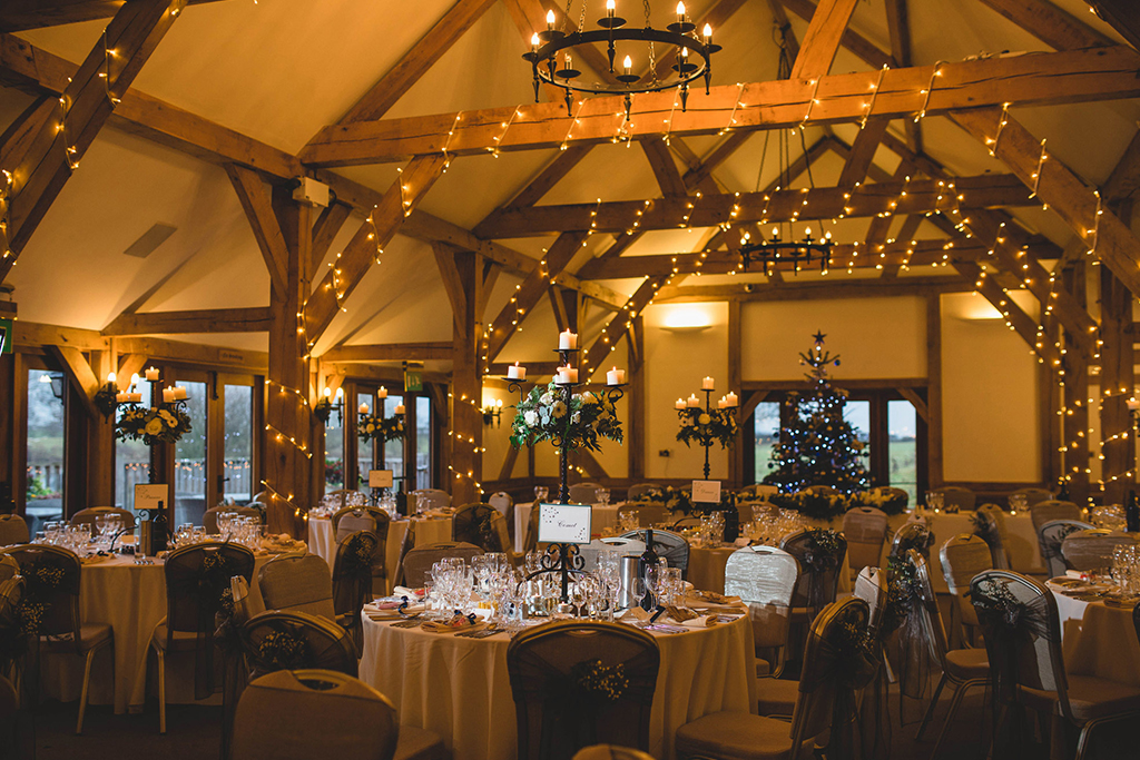 The wedding barn looks festive with fairy lights around the beams and the Christmas Tree for decoration.