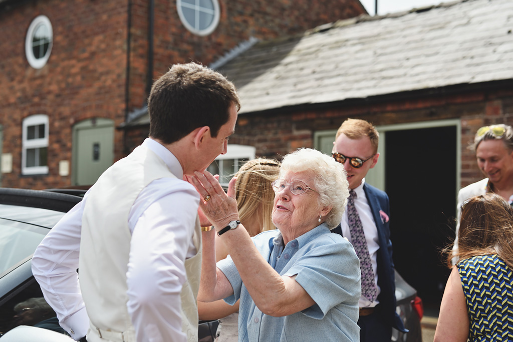 A family member shares some wise words with the groom before the wedding ceremony at Sandhole Oak Barn