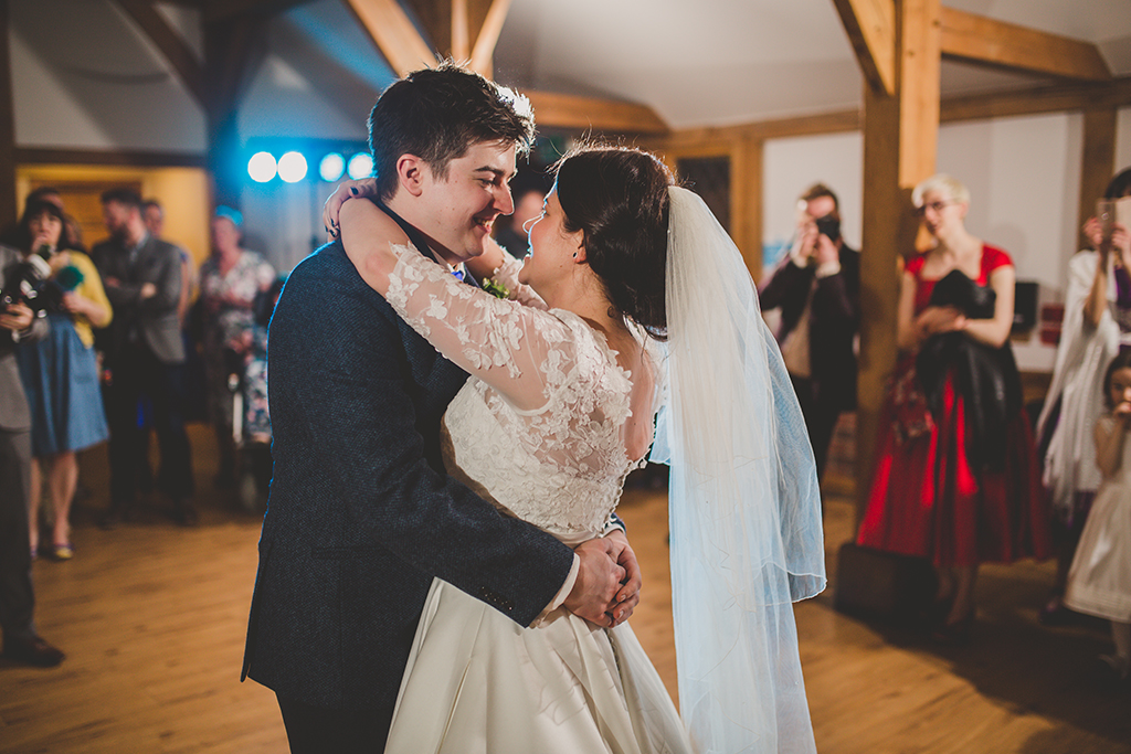 The happy couple have their first dance as their guests watch on at this barn wedding in Cheshire