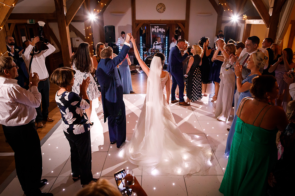 The happy couple enjoy their first dance as their guests watch on at their barn wedding at Sandhole