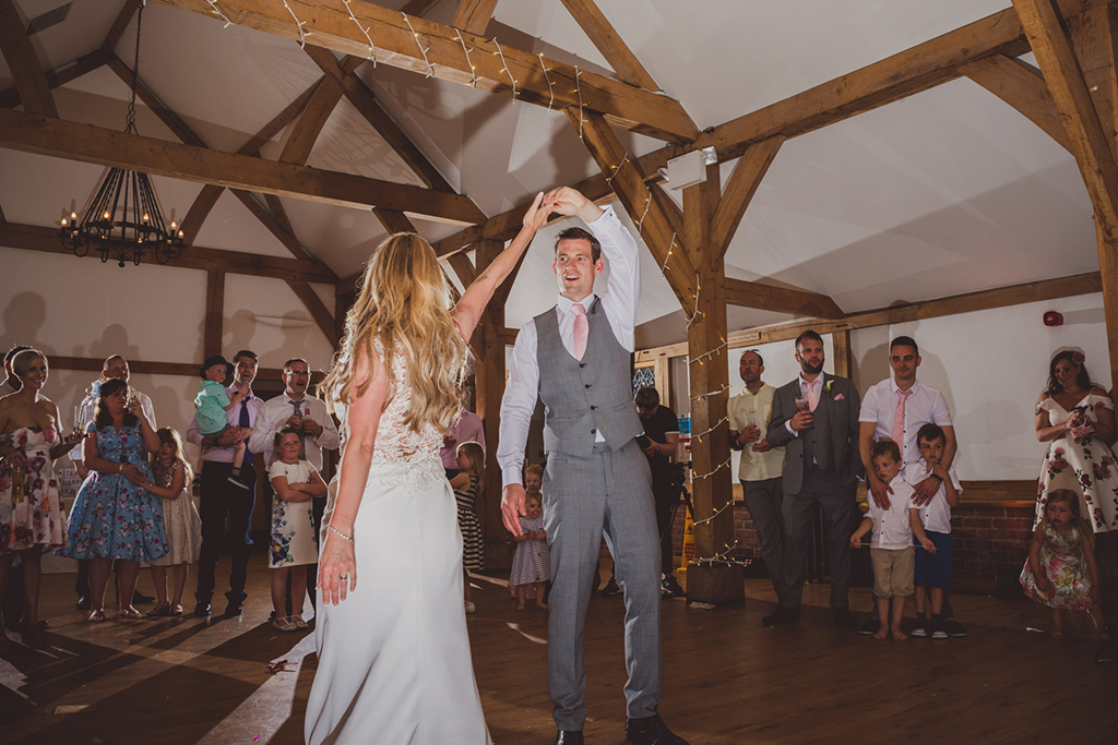 The newlyweds take to the floor for the first dance as their wedding guests look on at Sandhole Oak Barn 