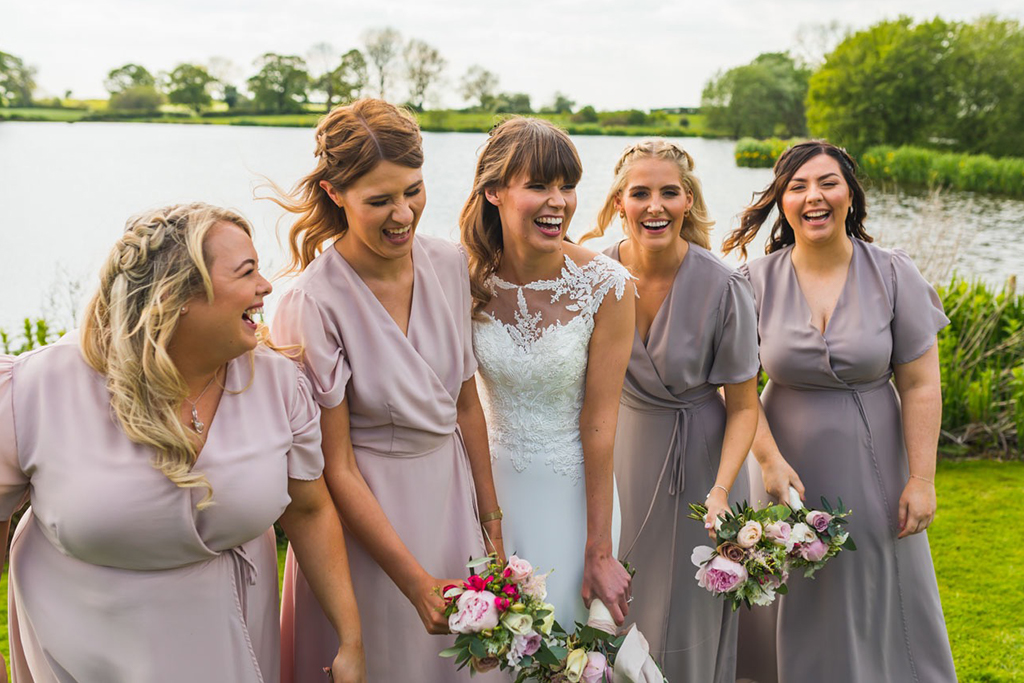 The bridesmaids wear pretty dusky pink bridesmaid dresses at this wedding at Sandhole Oak Barn