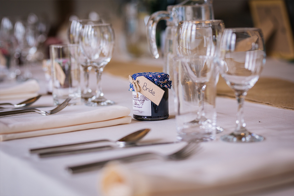 Small jars of homemade jam were given as wedding favours at this rustic barn wedding in Cheshire