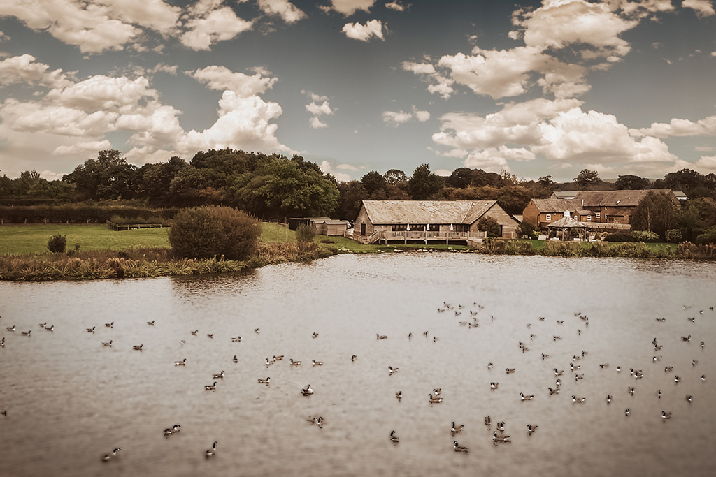 A beautiful view over the lake at rural wedding venue Sandhole Oak Barn in Cheshire