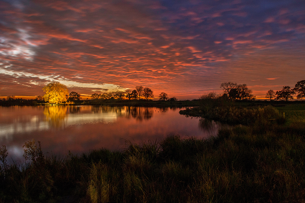 The stunning view over the lake at Sandhole Oak Barn creates the most beautiful wedding photos