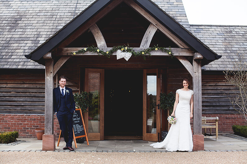 Lauren and Danny posing outside the rustic barn
