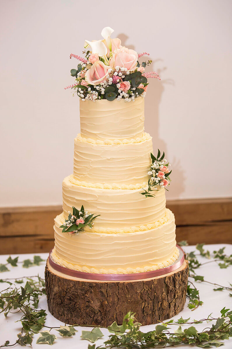 Cream 4 tiered wedding cake with floral decorations