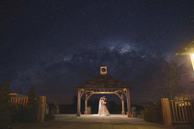Micaela and Garry under the clock tower at dusk