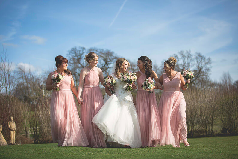 Micaela with her bridesmaids in blush pink dresses