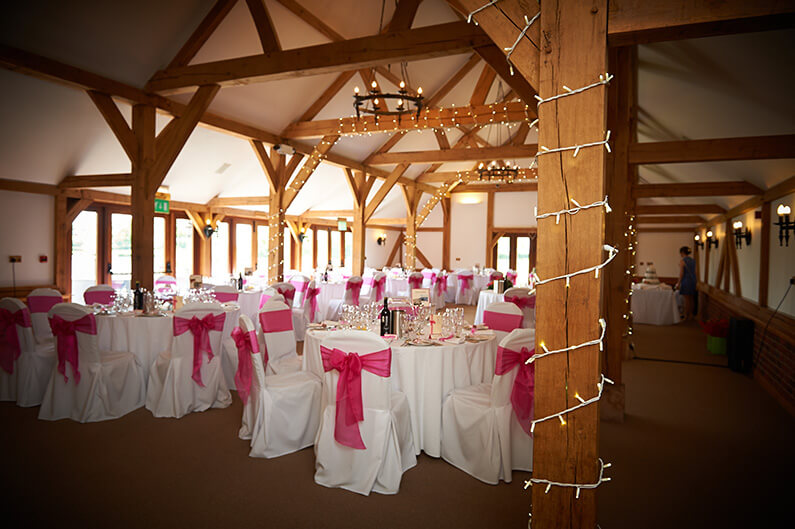 White chair covers with bright pink sashes