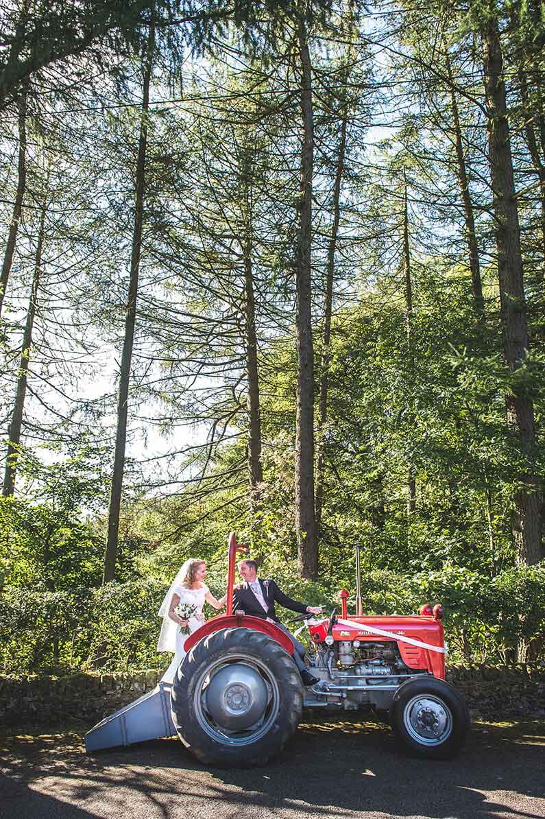 Rachel and Norman with a red tractor at Sandhole Oak Barn