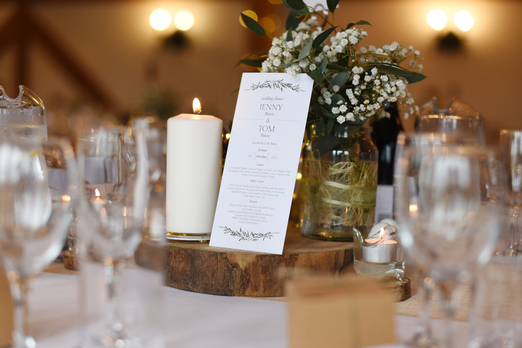 The wedding menus were displayed on rustic wood slices at this barn wedding at Sandhole Oak Barn