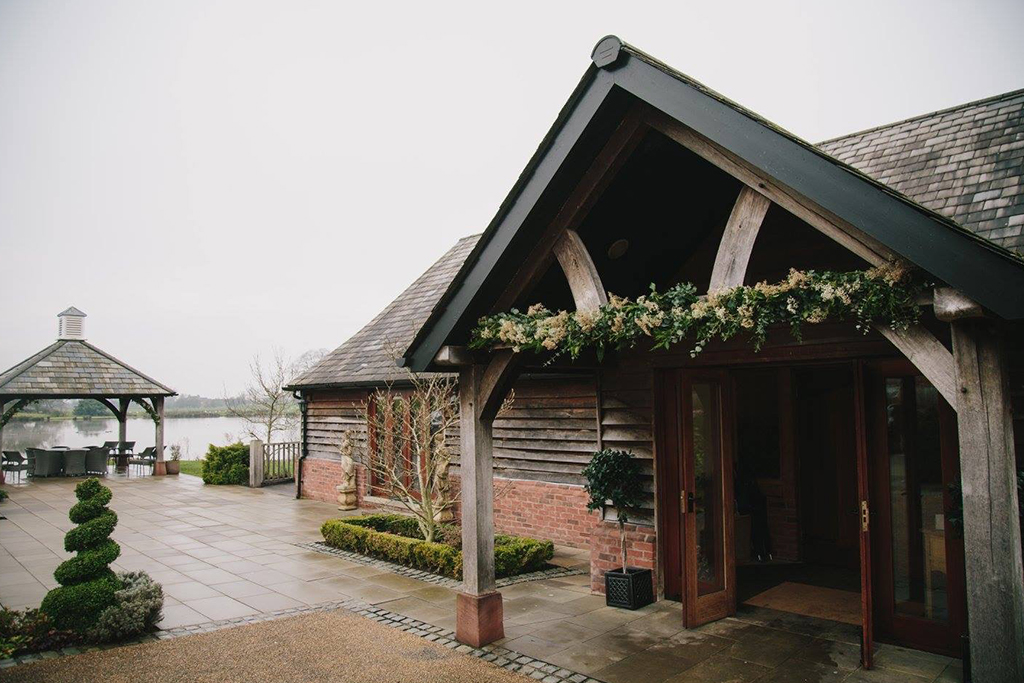 The entrance to the barn was decorated with a festive garland at this winter wedding in Cheshire