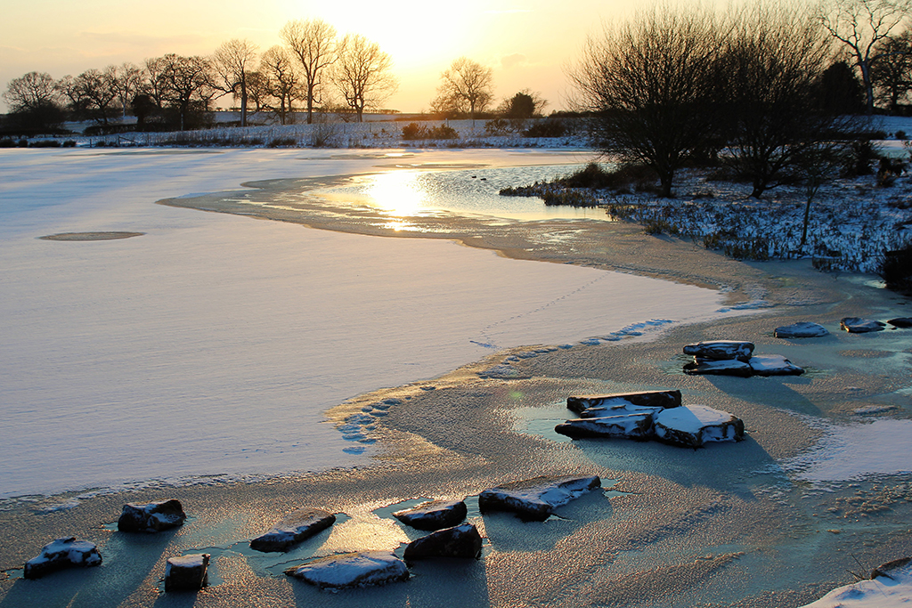 The snow covered lake and fields at Sandhole Oak Barn look simply stunning in the sunset, the perfect setting for your winter wonderland wedding