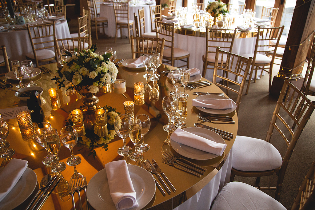 The tables were decorated with gold table-toppers and lots of pretty gold tealight holders at this spring wedding at Sandhole Oak Barn near Staffordshire