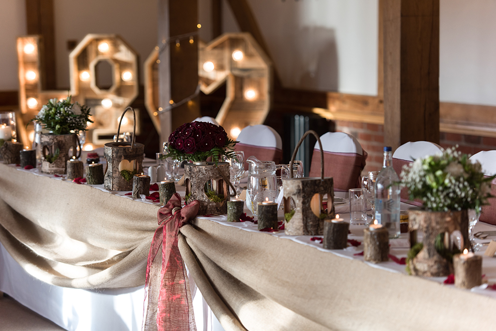 The top table has been decorated beautifully for a winter wedding at Sandhole Oak Barn in Cheshire
