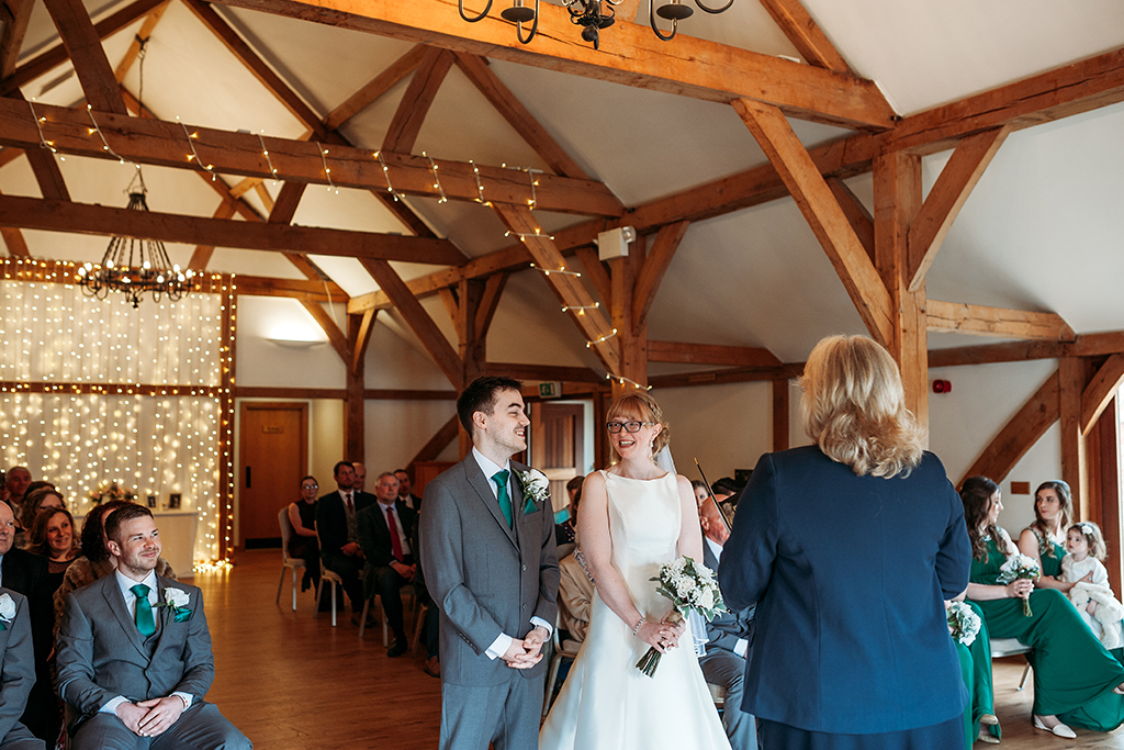 The happy couple say their vows at their wedding ceremony at Sandhole Oak Barn in Cheshire 