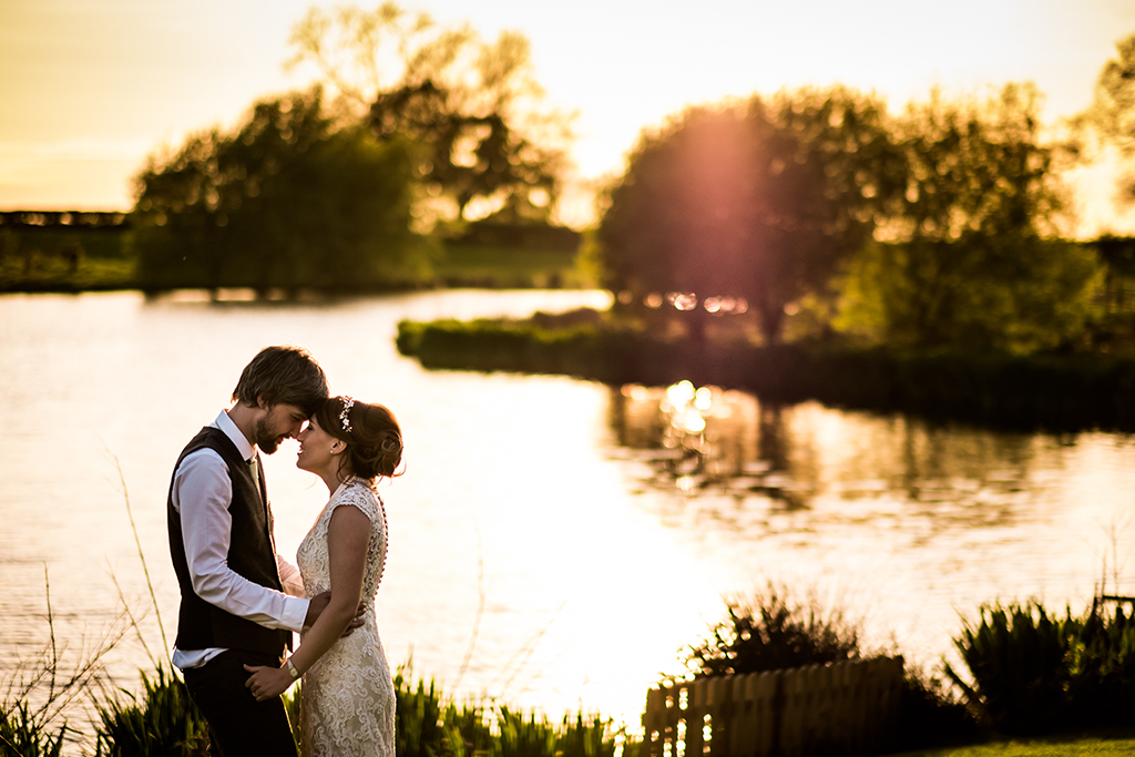 The lake at sunset offers the most beautiful backdrop to your wedding photos at Sandhole Oak Barn in Cheshire