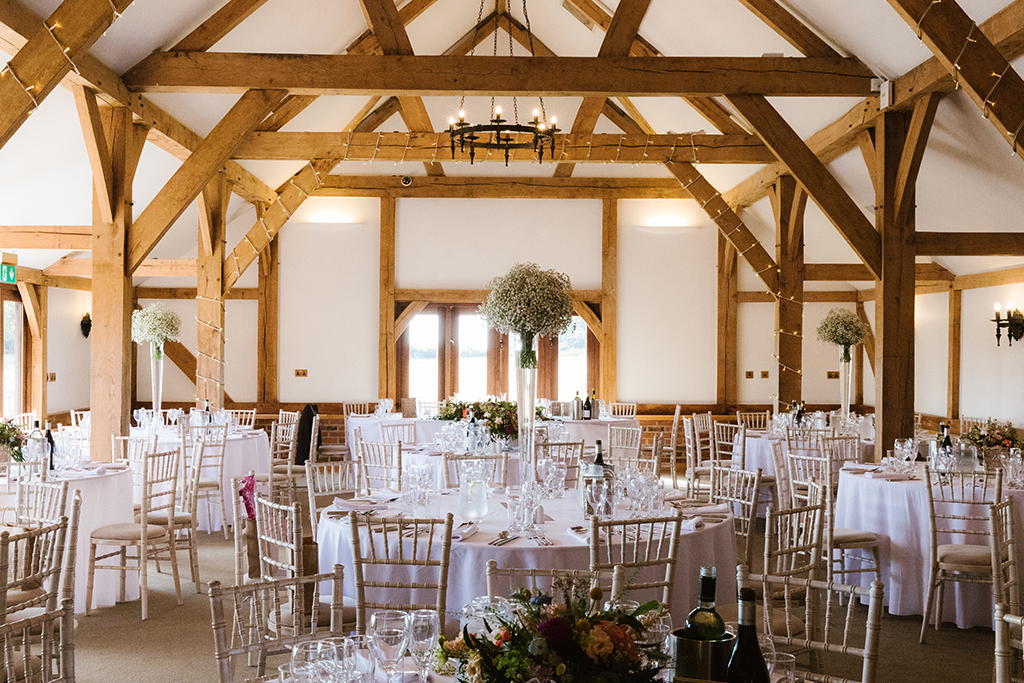 The oak barn was set up for the wedding breakfast with large arrangements pretty gypsophila as table centrepieces