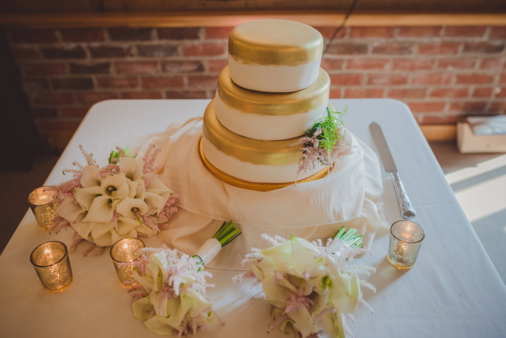 The bride chose a simple but elegant 3 tier wedding cake decorated with delicate flowers for her barn wedding at Sandhole Oak Barn. 