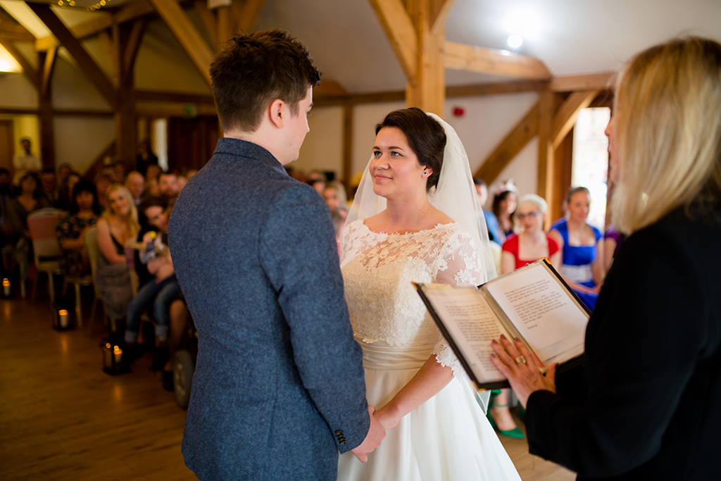 The bride and groom say their vows at their wedding ceremony at Sandhole Oak Barn in Cheshire
