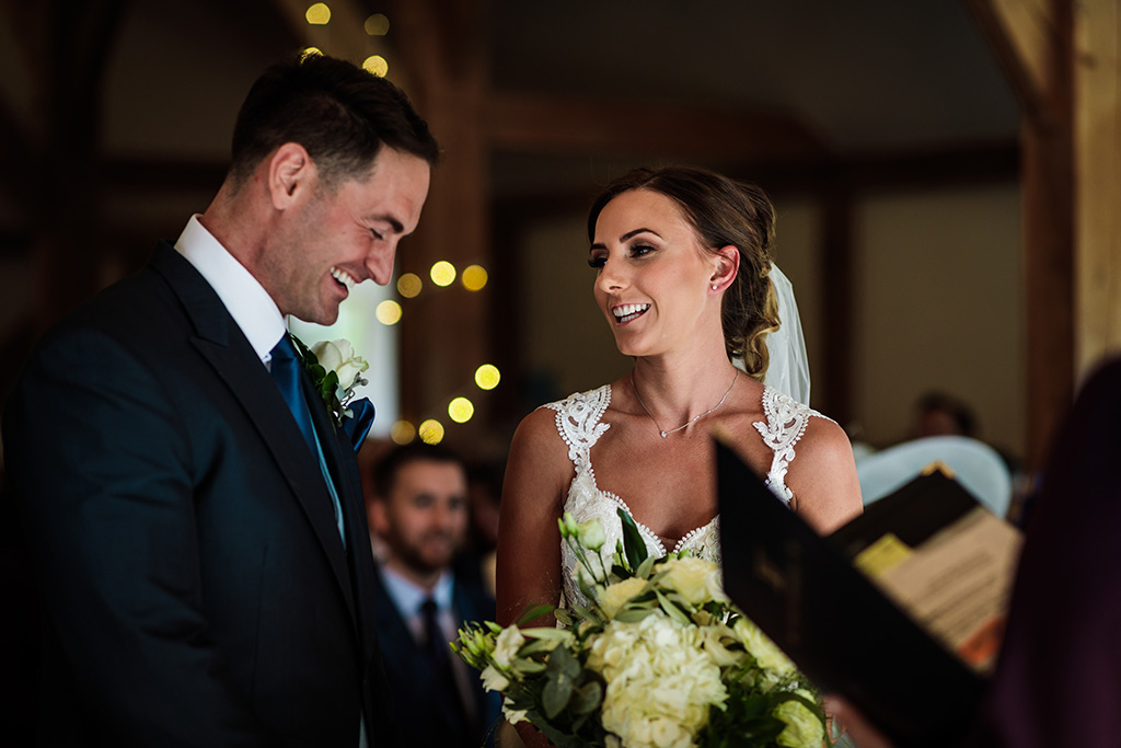 The bride and groom hold each other at their wedding ceremony at Sandhole Oak Barn in Cheshire