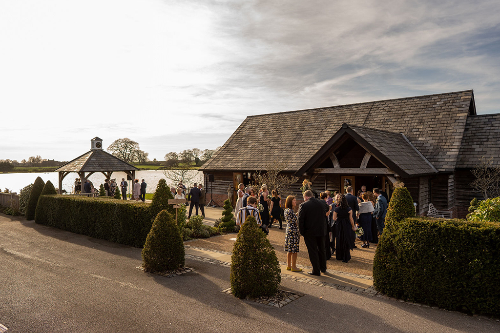 Wedding guests enjoy mingling in the winter sunshine at Sandhole Oak Barn