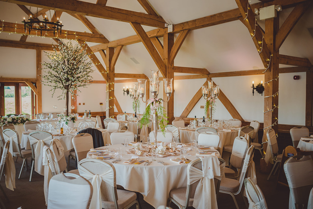 The Oak Barn was set up for the wedding breakfast with tall candelabras as centrepieces at this barn wedding